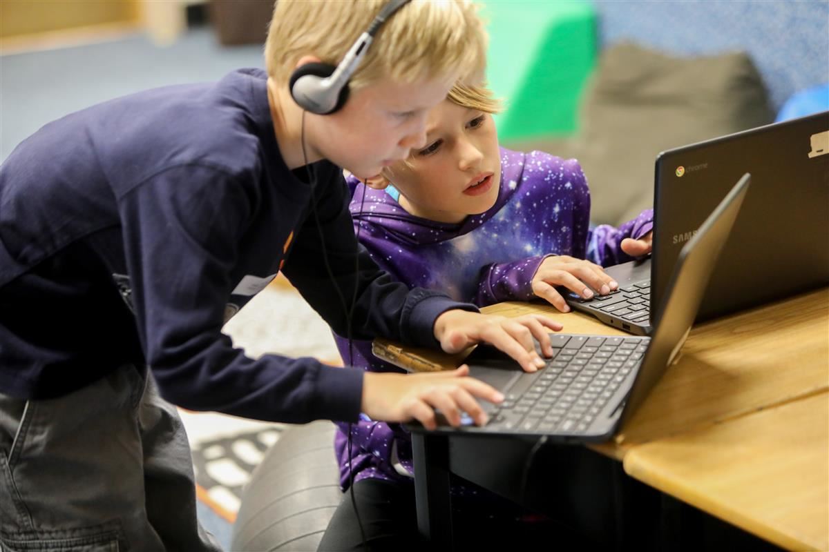 Two elementary aged students at their computers 