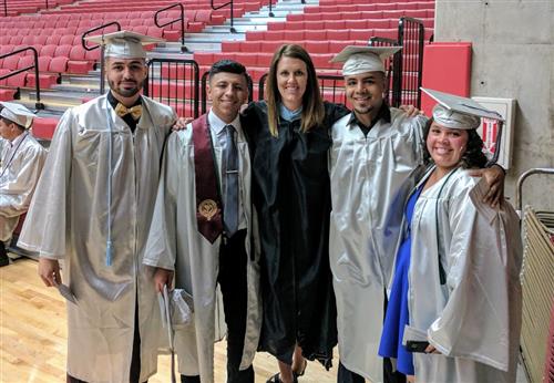 Counselor stands with graduating seniors 