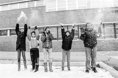 Students playing in the snow on the playground 
